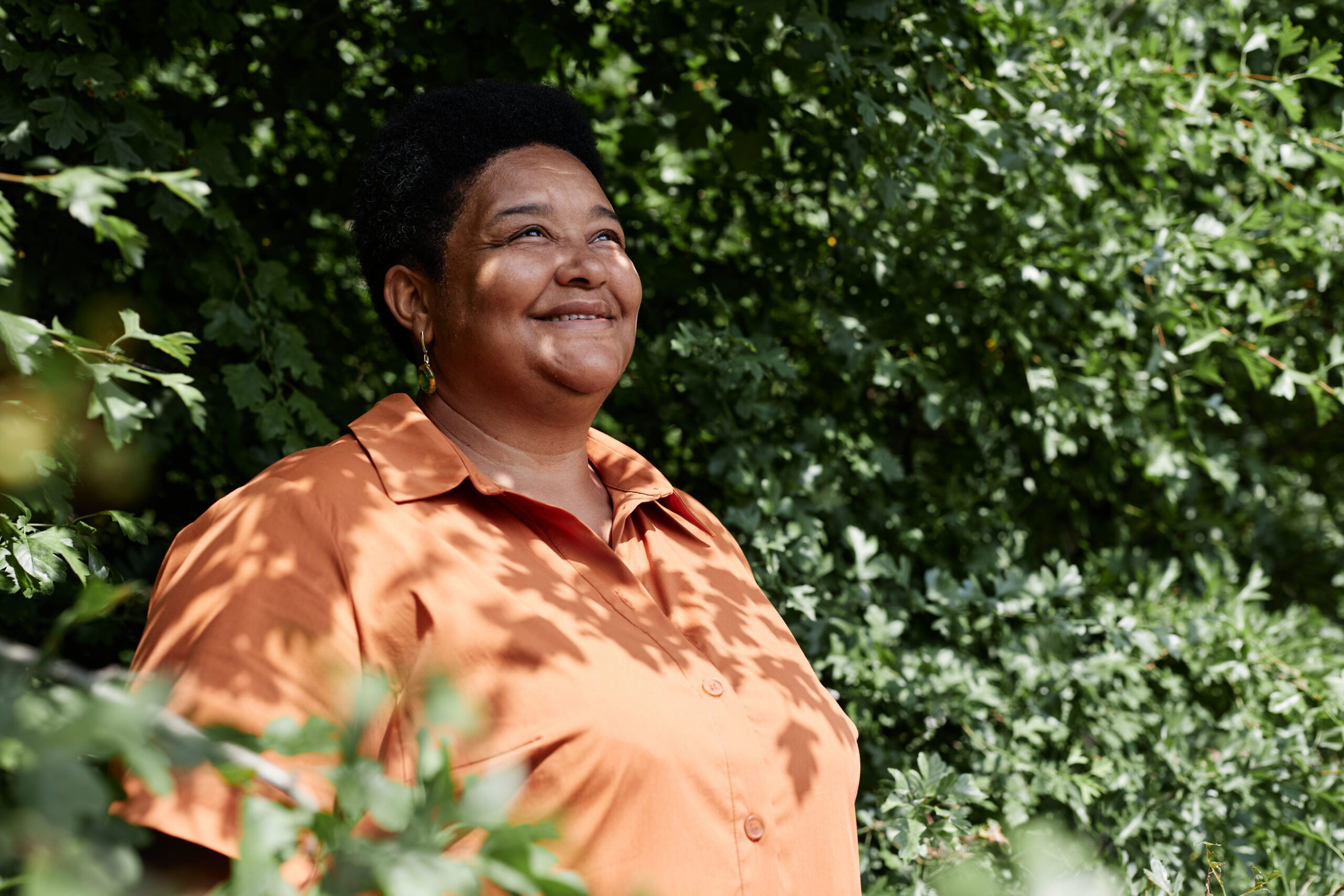 <p>Portrait of senior Black woman looking away against greenery outdoors, copy space</p>
